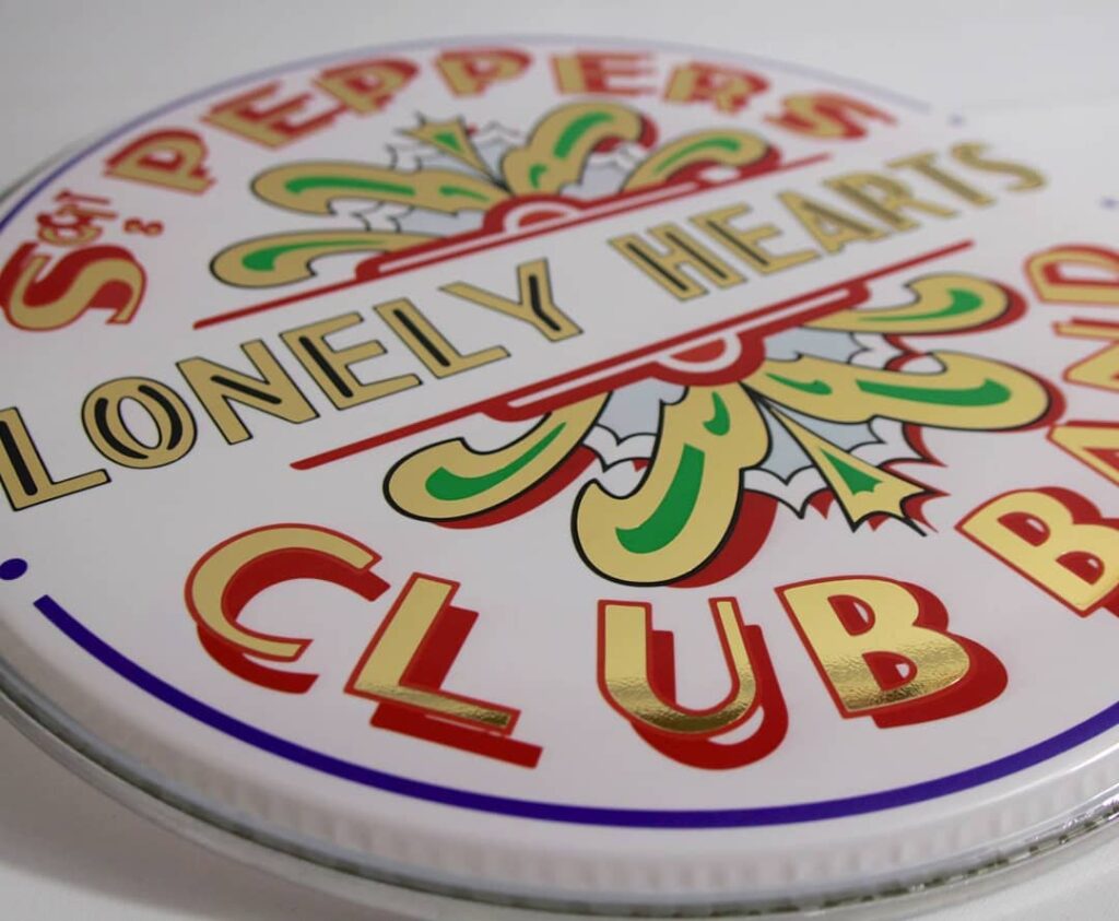 Peau de grosse-caisse personnalisée Beatles "Sgt. Pepper's Lonely Hearts Club Band" combinant impression directe et sticker à effet.